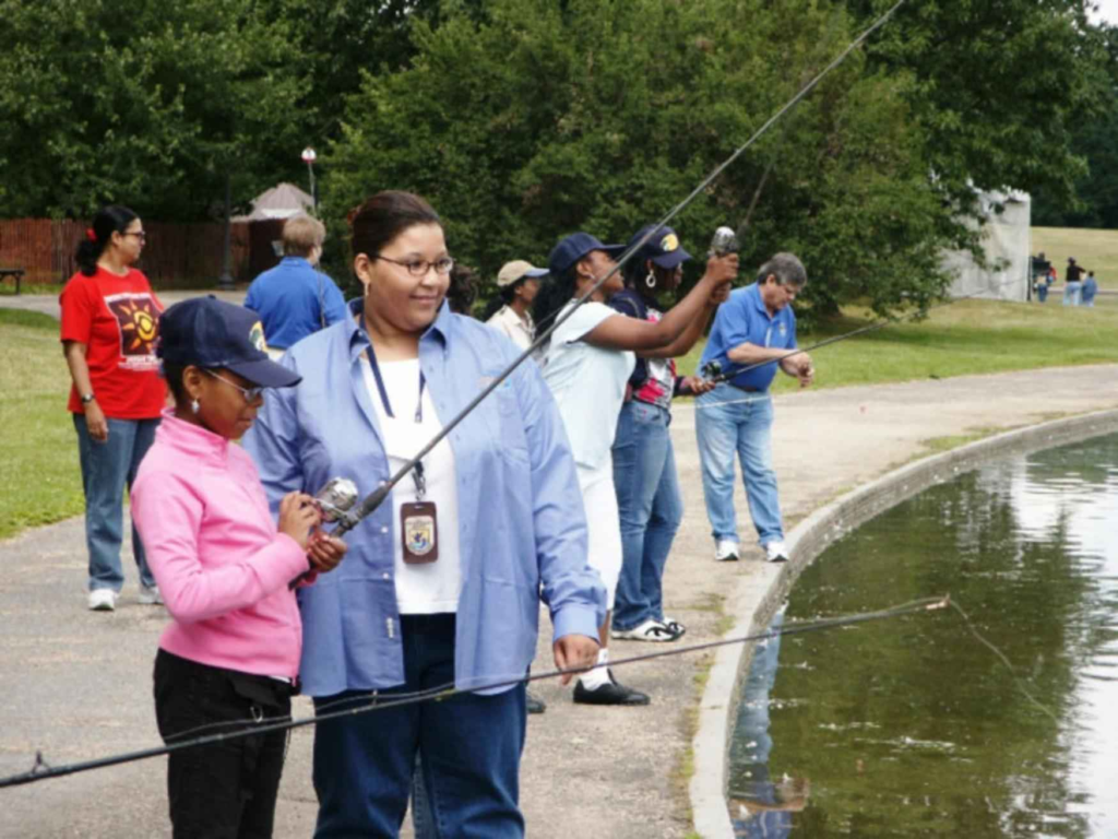 Adult woman and children fishing together on a lake